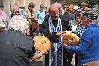 Pfarrer beim Brotschneiden